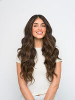 Smiling woman with long wavy dark hair showcasing the natural look of Extra Hair Extension Piece - 