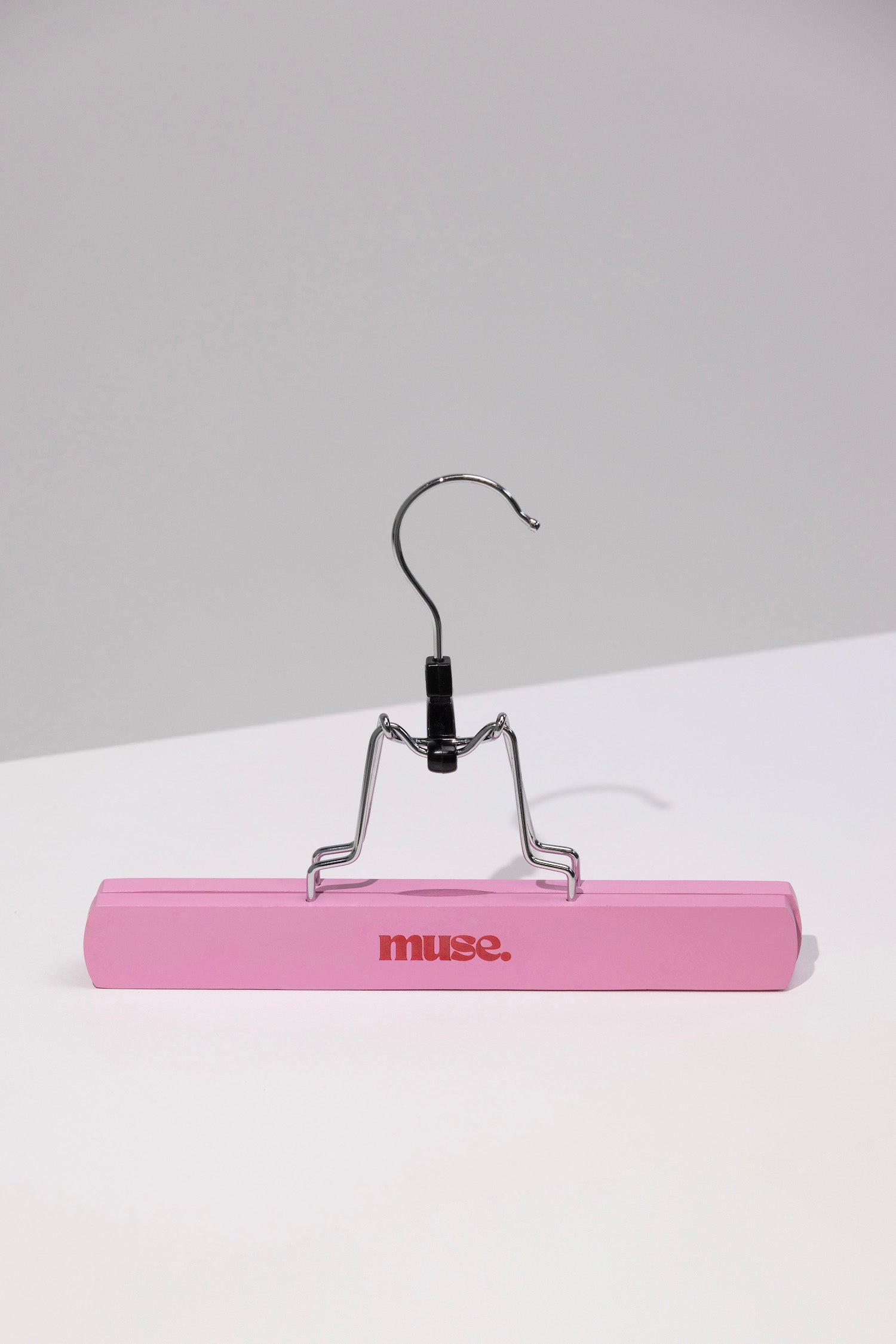 Pink wooden hanger with metal clip for organizing hair accessories in the Hair Extension Storage Bag & Hanger
